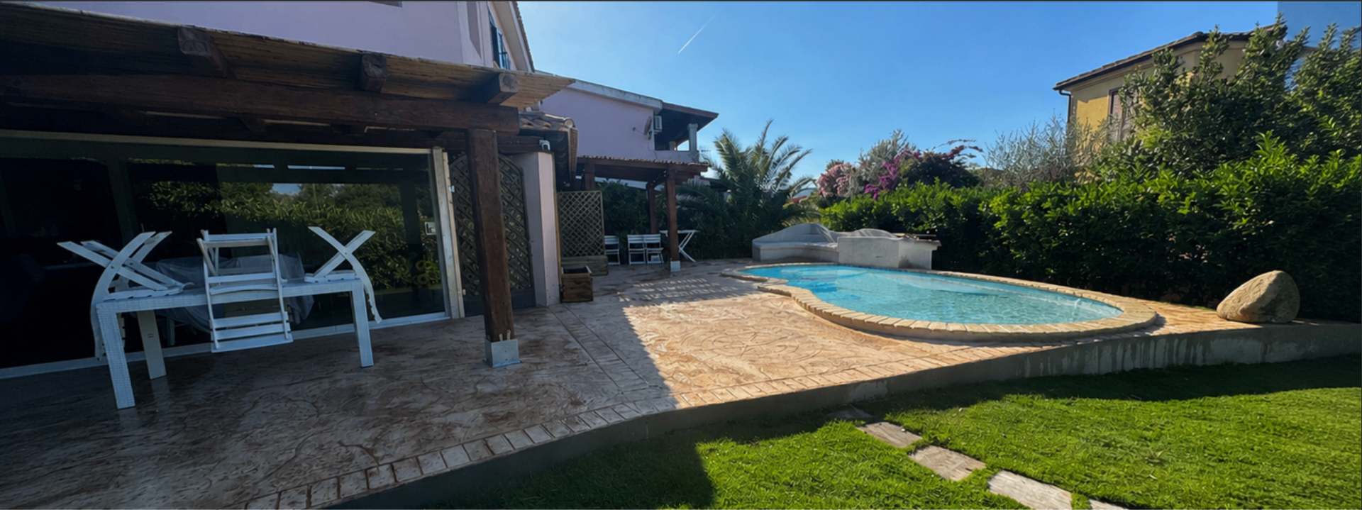 Vista panoramica della piscina con veranda e giardino