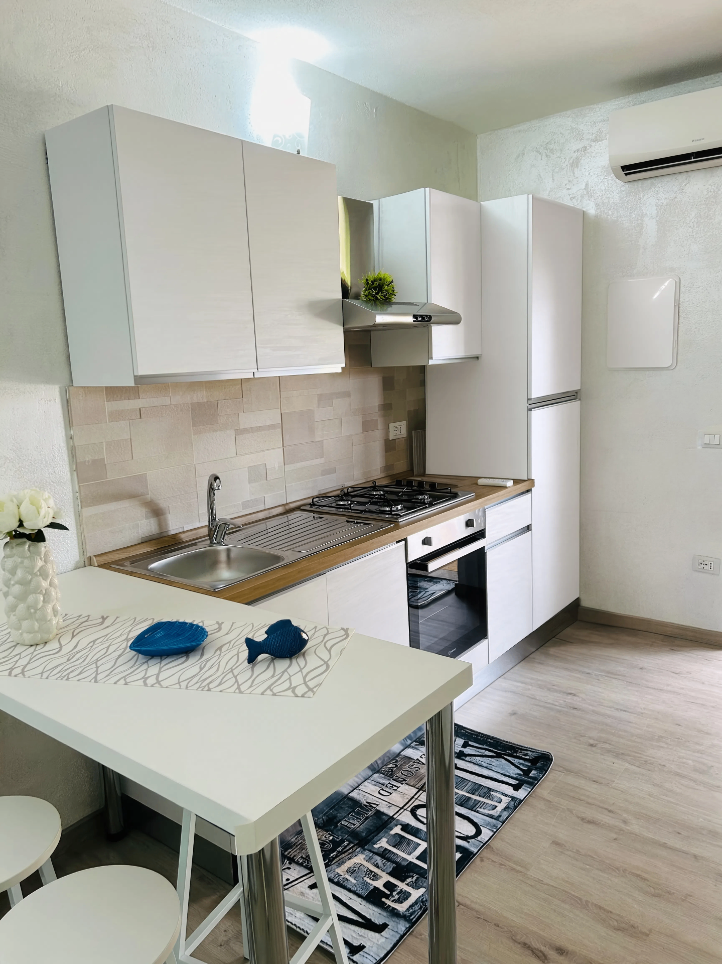 Cucina attrezzata con forno, piano cottura e frigorifero